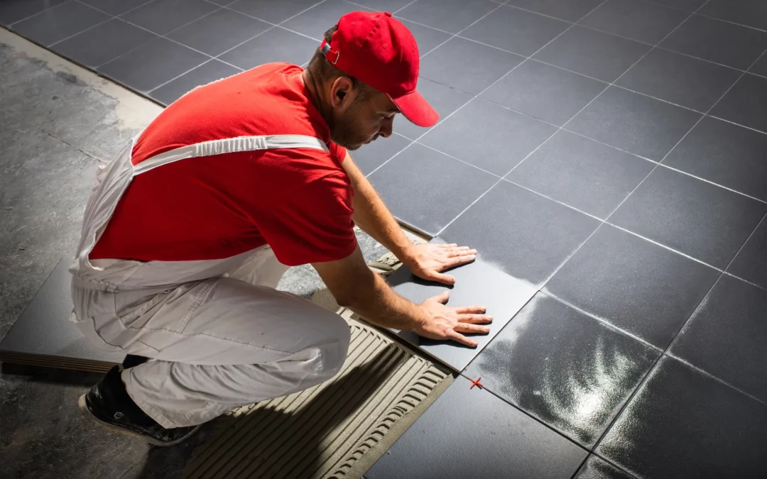 Carreleur posant du carrelage gris