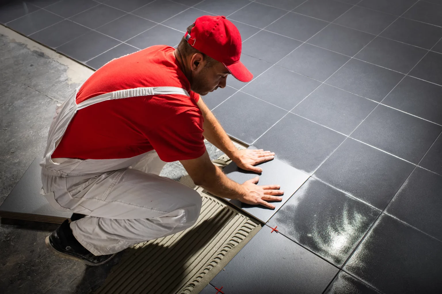 Carreleur posant du carrelage gris