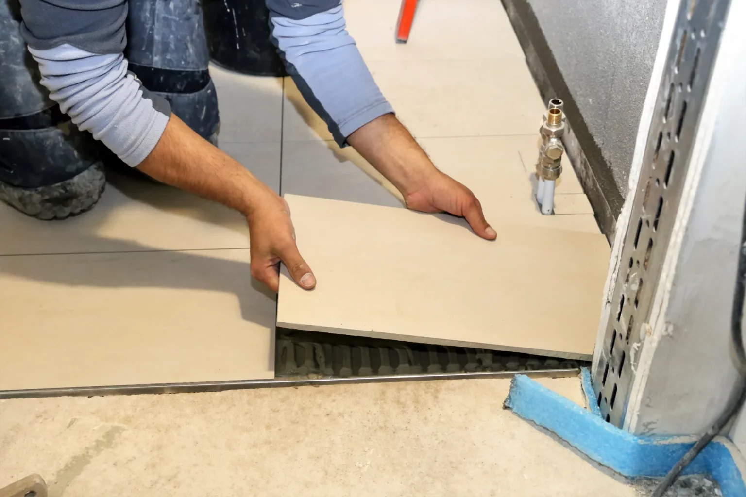 Plombier posant du carrelage